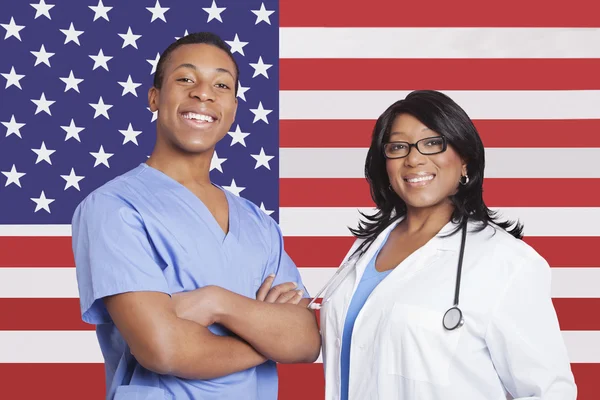 Manliga och kvinnliga kirurger över amerikanska flaggan — Stockfoto