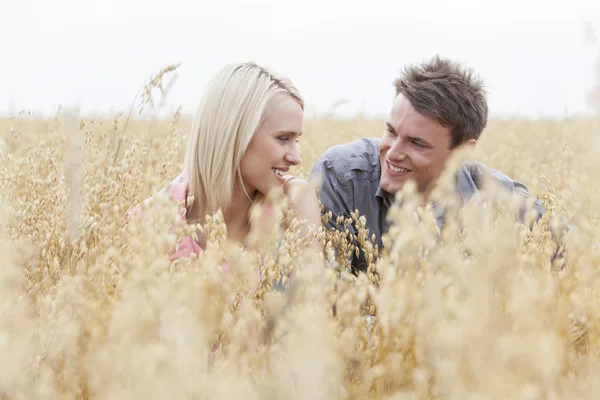 Hombre y mujer relajándose en medio del campo — Foto de Stock