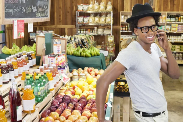 Uomo che usa il telefono al supermercato — Foto Stock