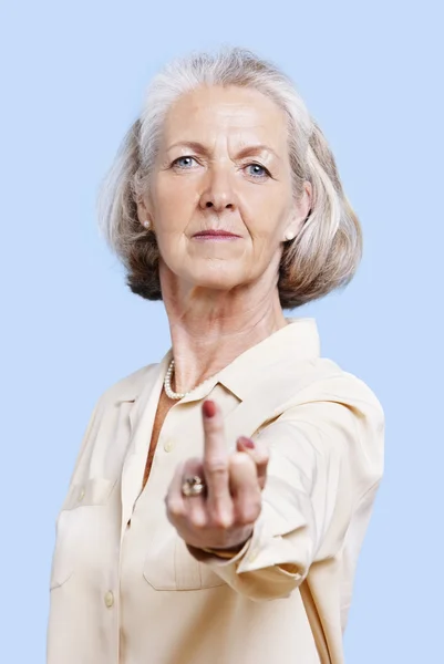 Senior woman making rebellious hand gesture — Stock Photo, Image