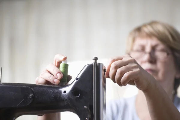 Reife Frau Fäden Nähmaschine — Stockfoto