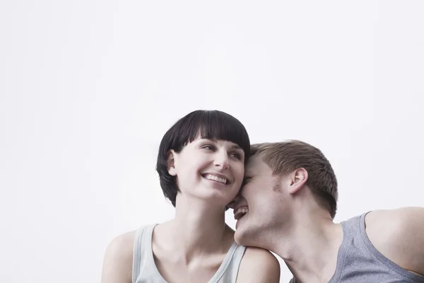 Young couple sit laughing in vest tops copyspace — Stock Photo, Image