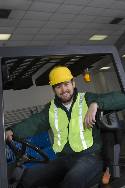 Man sitting on fork lift truck — Stock Photo, Image