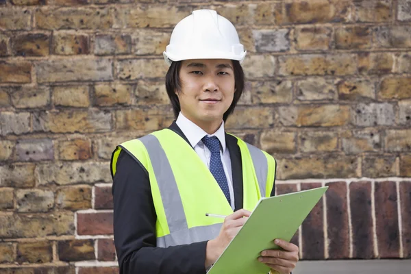 Supervisor holding clipboard at construction site — Stock Photo, Image