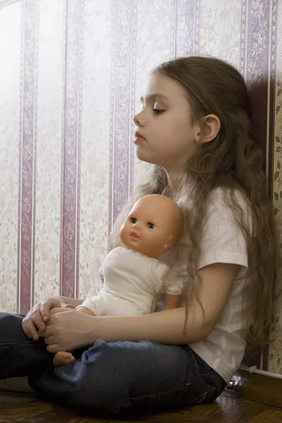 Дівчина з лялькою сидить — стокове фото