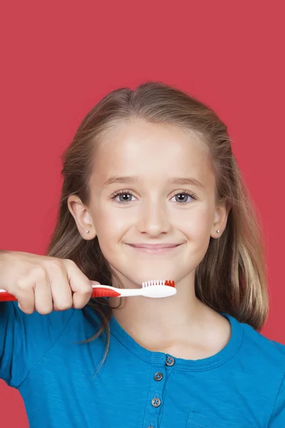 Jente som holder tannbørste – stockfoto