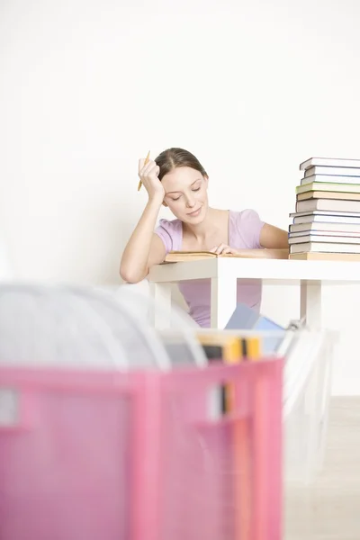 Jovem mulher senta-se trabalhando em livros — Fotografia de Stock