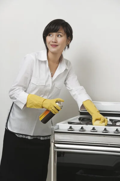 Maidservant cleaning stove — Stock Photo, Image