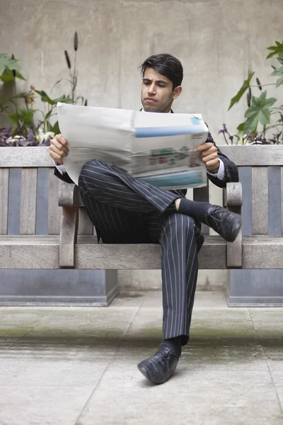 Индийский бизнесмен читает газету — стоковое фото