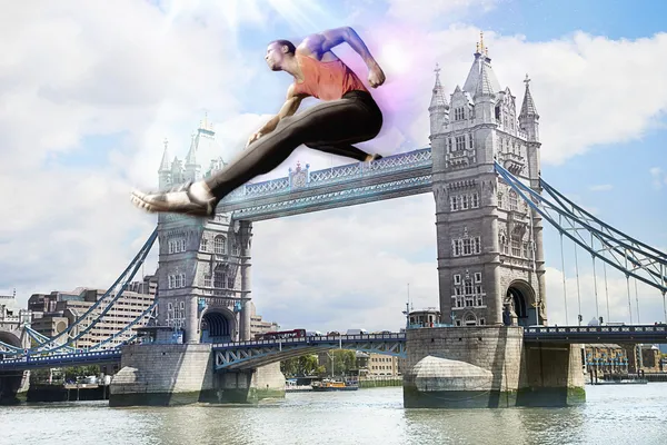 Atleta masculino hurdling Tower Bridge — Fotografia de Stock