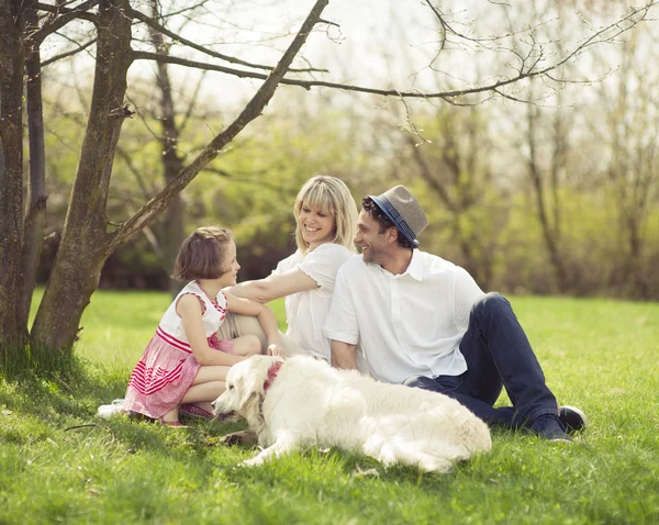 Family in park with dog — Stock Photo, Image