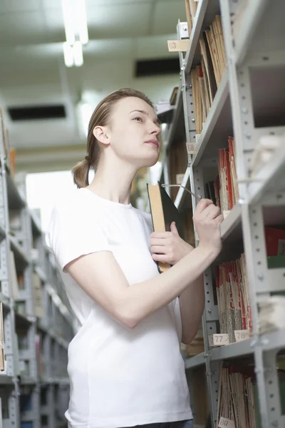 Junge Frau in der Bibliothek — Stockfoto