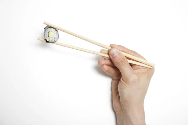 Rollo de sushi de mano en palillos —  Fotos de Stock