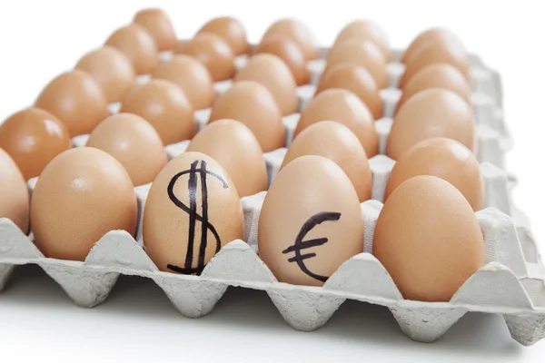 Яйца в коробке с долларом, знак евро — стоковое фото
