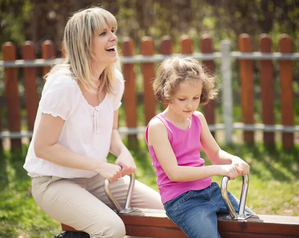 Madre e figlia cavalcare altalena — Foto Stock