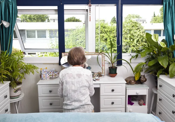 Vrouw zitten op dressoir in slaapkamer — Stockfoto