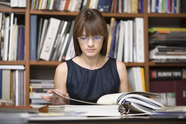 Jeune designer est assis à la recherche dans la bibliothèque — Photo