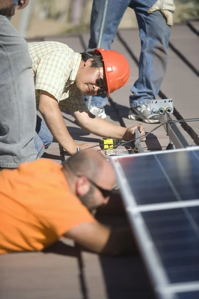 Люди, работающие на солнечных панелях — стоковое фото