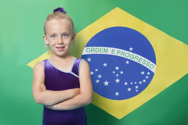 Joven gimnasta femenina frente a la bandera brasileña — Foto de Stock