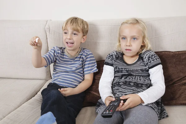 Bror och syster tittar på TV — Stockfoto