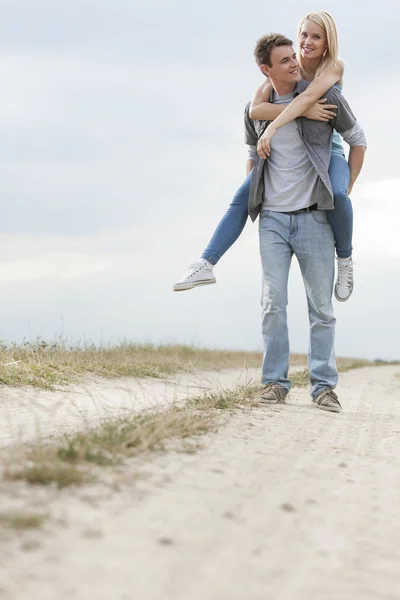 Hombre dando paseo a cuestas a la mujer — Foto de Stock