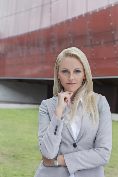 Femme d'affaires debout avec la main sur le menton — Photo