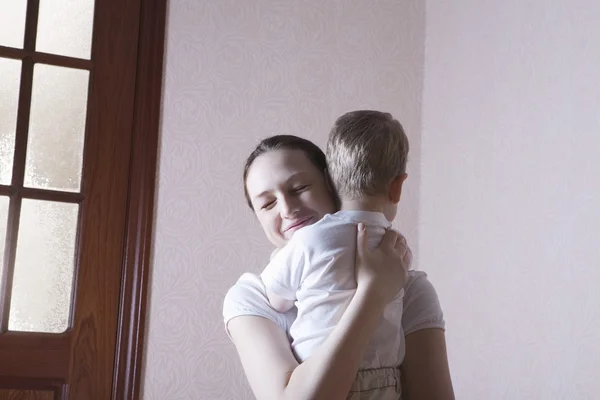 Matka usměje štěstí při objímání svého syna — Stock fotografie