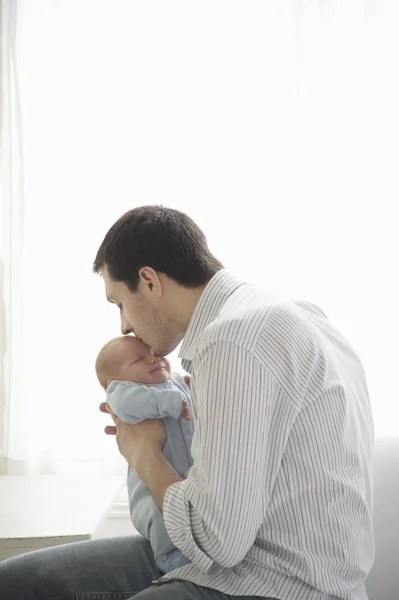 Father kisses two week old newborn babies head — Stock Photo, Image