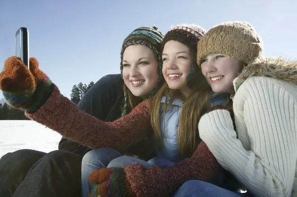 Tres chicas toman autorretrato con teléfono de la cámara — Foto de Stock