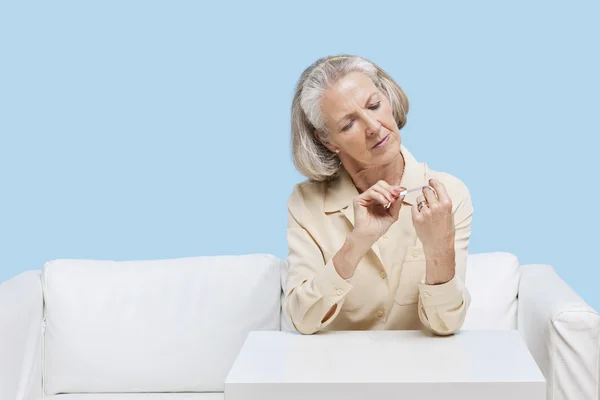 Senior woman filing nails — Stock Photo, Image