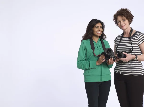 Dvě ženy držící digitální fotoaparáty — Stock fotografie