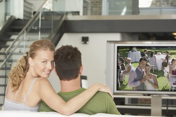 Femme avec homme regardant un film à la télévision — Photo