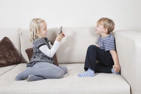 Girl photographing brother — Stock Photo, Image