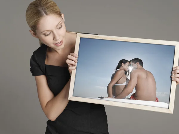 Businesswoman looking at photograph — Stock Photo, Image