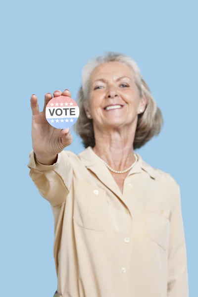 Senior woman holding election badge — Stock Photo, Image