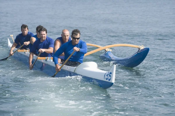 Outrigger paddling team på vatten — Stockfoto