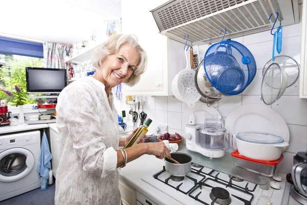 Seniorin bereitet Essen zu — Stockfoto