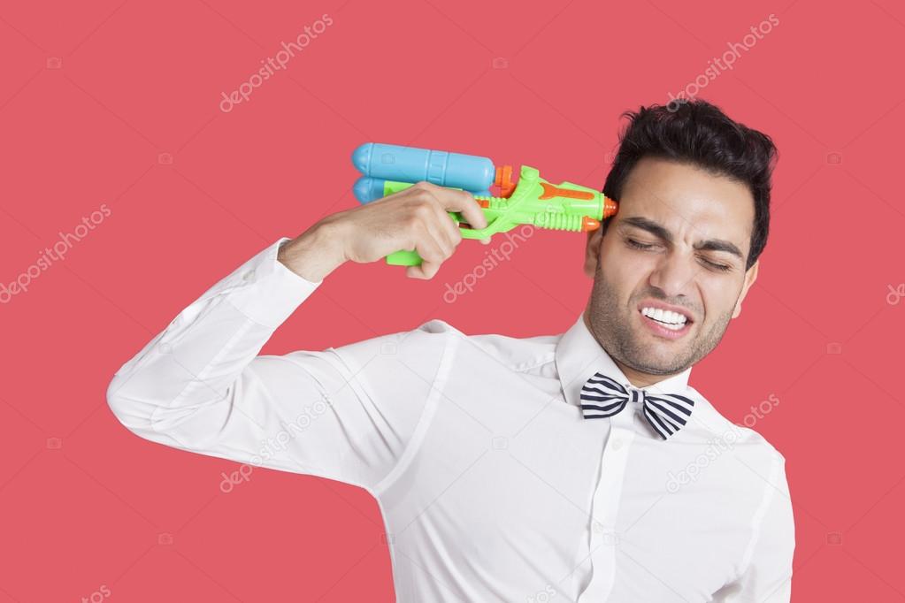 Frustrated man holding toy gun