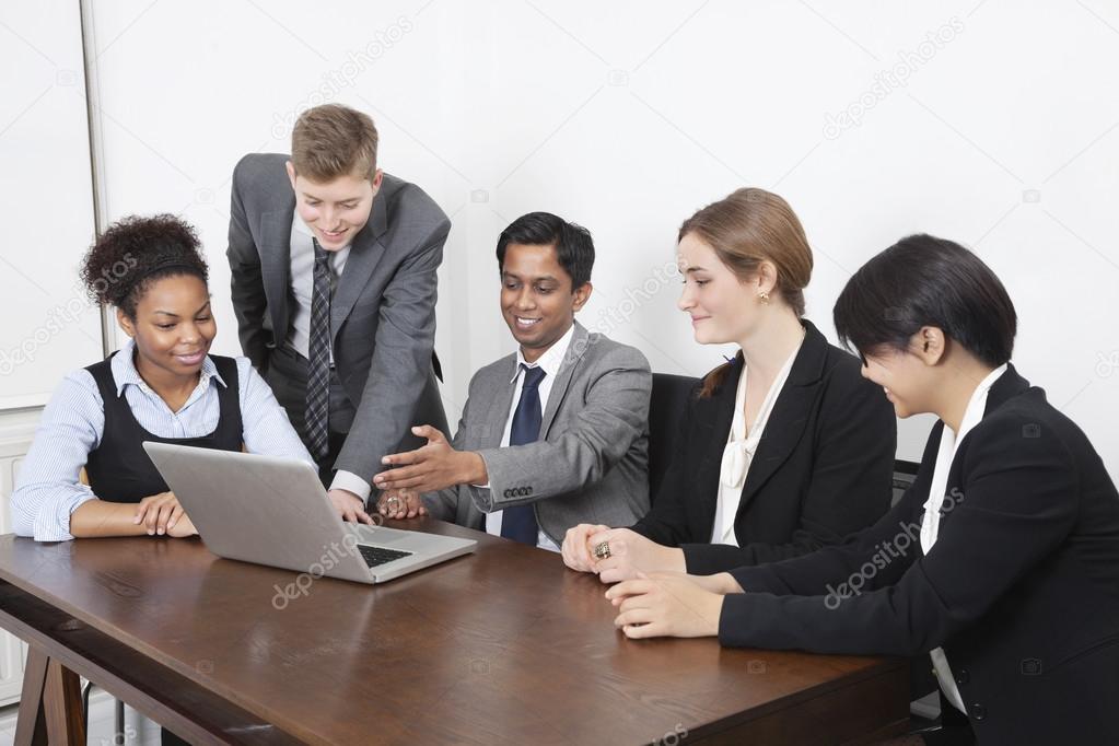 Multiethnic professionals using laptop