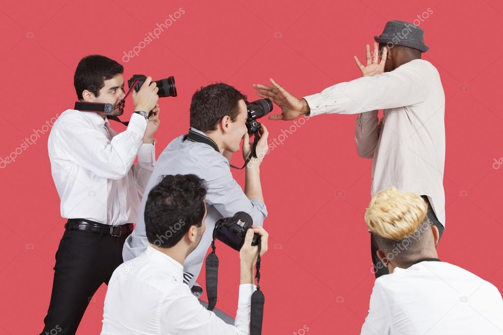 Celebrity shielding face from photographers