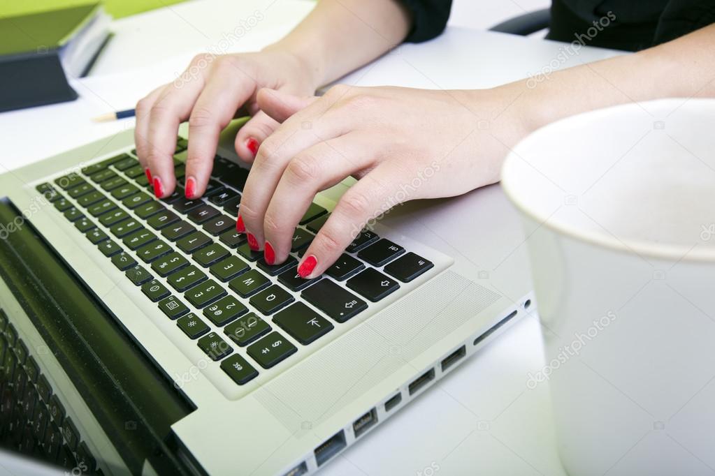 Womans hands typing on laptop