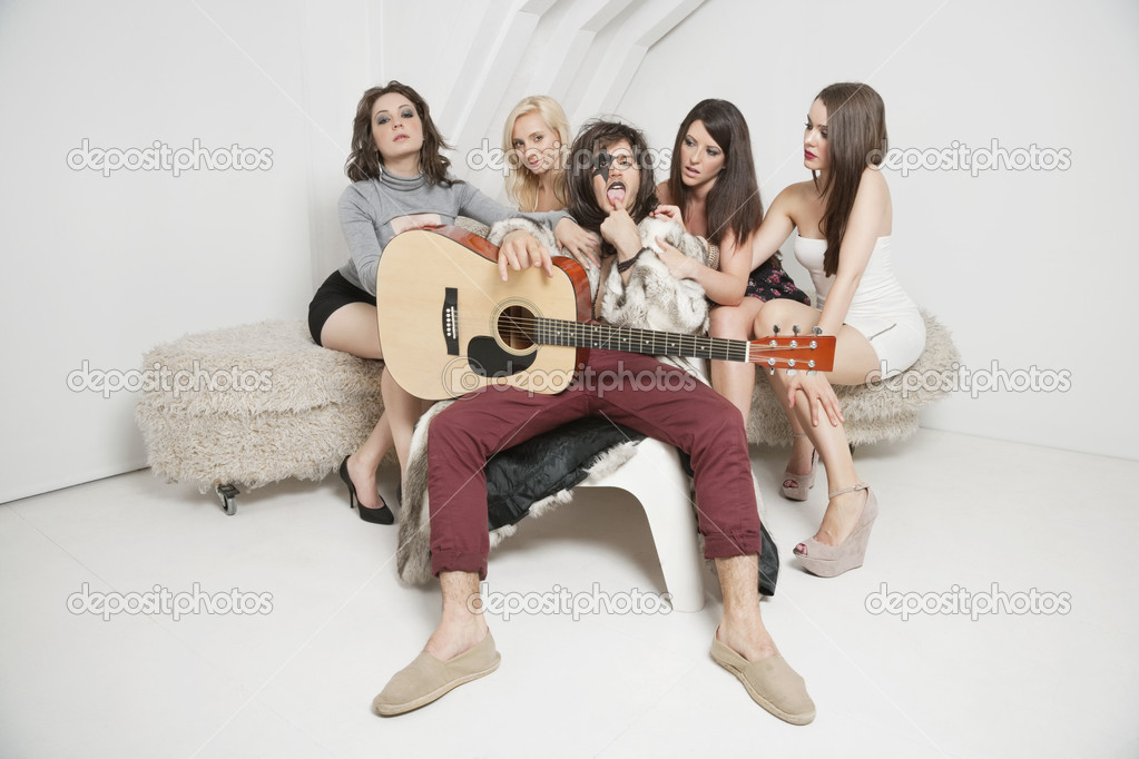 Guitarist sitting amid female friends