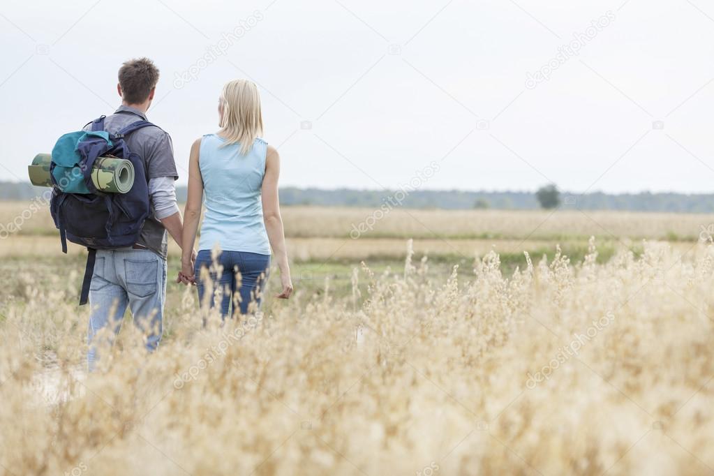 hiking couple walking through field