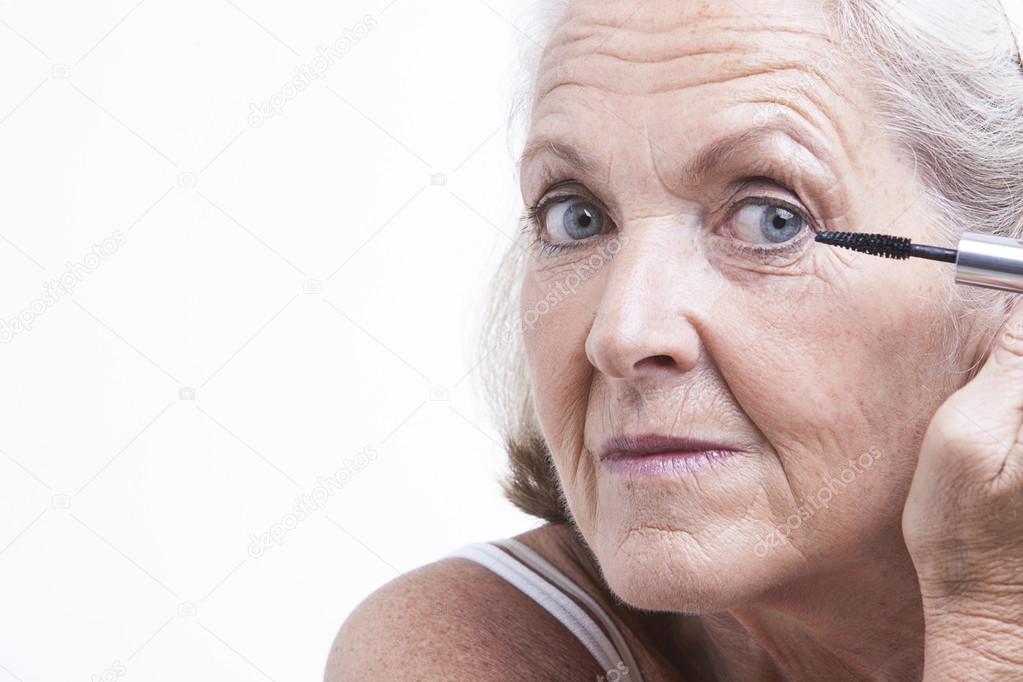 Senior woman applying mascara