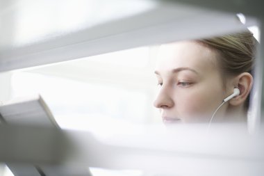 Kütüphanede okuyan genç bir kadın.