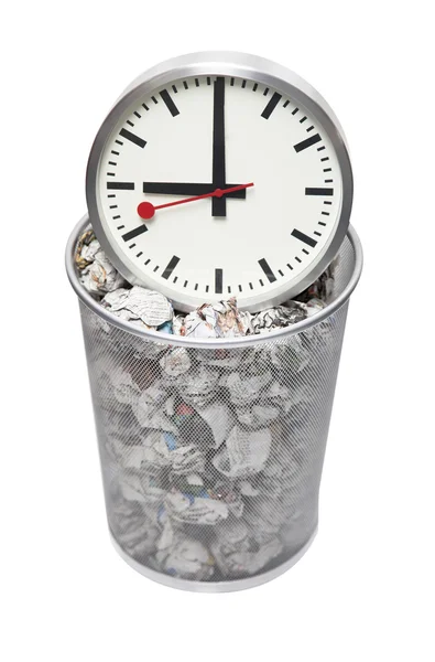 Clock in wastebasket full of crumpled paper — Stock Photo, Image