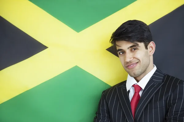 Podnikatel proti jamajské vlajky — Stock fotografie