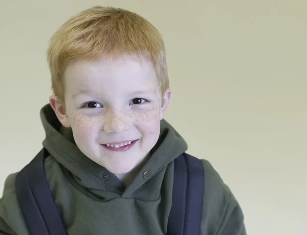 Schooljongen met redhair en sproeten staat met rugzak — Stockfoto