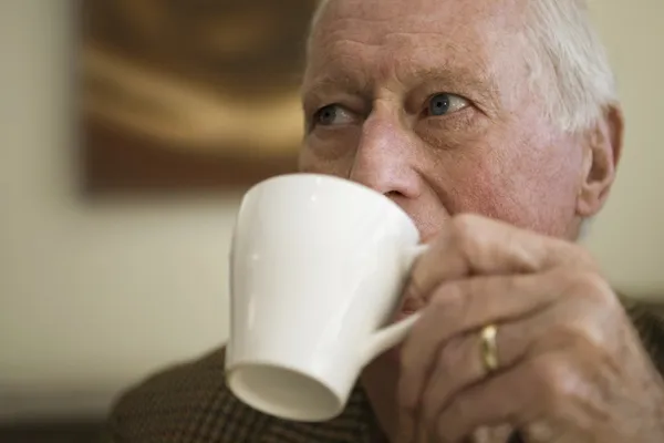 Uomo anziano pensieroso che beve tè — Foto Stock