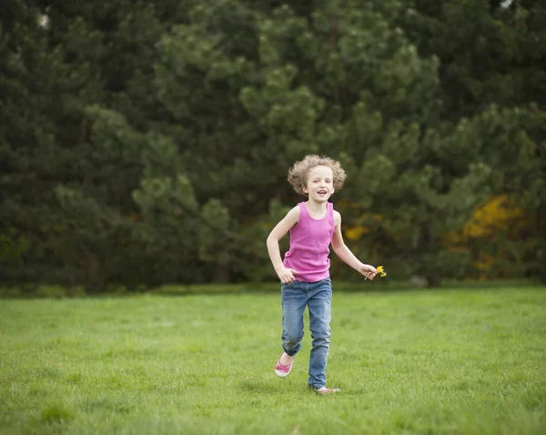 Flicka kör genom park — Stockfoto